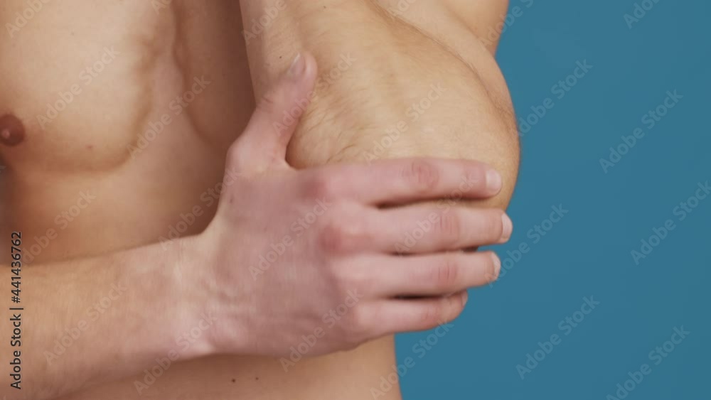 Treatment of sore joints. Close up shot of unrecognizable man applying healing cream on his elbow, suffering from pain Treatment of sore joints. Close up shot of unrecognizable man applying healing cream on his elbow, suffering from pain