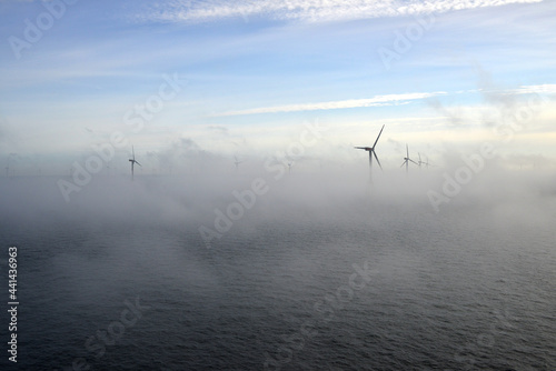 Offshore windfarm at dusk with fog