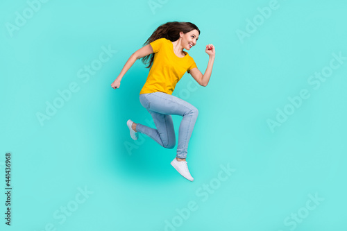 Full body profile photo of funny young lady run wear yellow t-shirt jeans isolated on teal color background