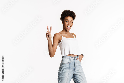 Young black woman in tank top smiling and gesturing at camera
