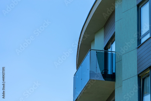 Modern European residential apartment building with balconies on blue sky background