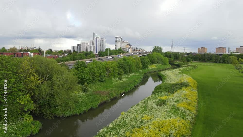 Brook flowing along with busy road, tall buildings in urban neighbourhood. Brook flowing along with busy road, tall buildings in urban neighbourhood.
