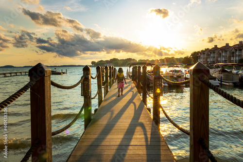 Tapety artystyczne Young girl on dock at sunset