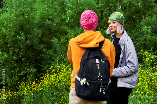 teenagers chatting outdoors on green foliage background