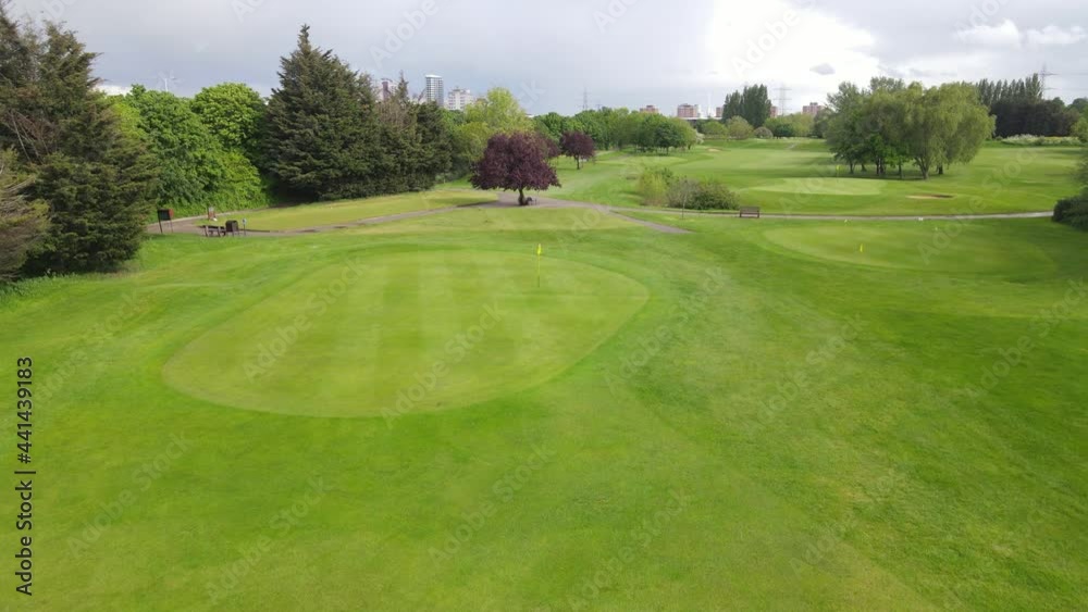 course lined with trees. City skyline with tall modern buildings in background. Overcast sky course lined with trees. City skyline with tall modern buildings in background. Overcast sky
