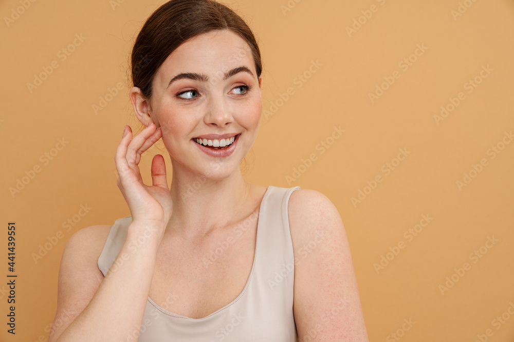 Young ginger woman in undershirt smiling and looking aside Young ginger woman in undershirt smiling and looking aside