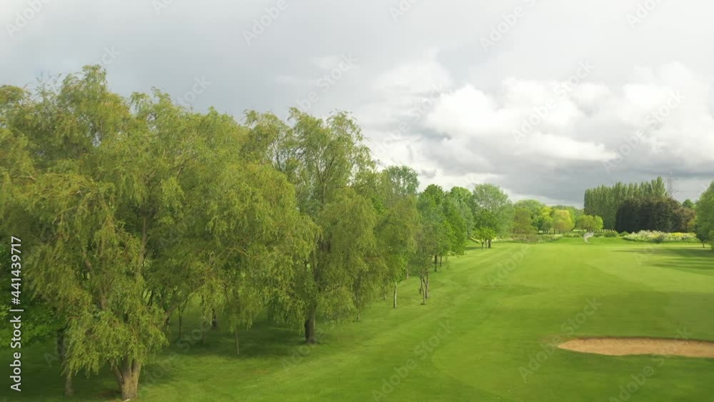downtown skyline above trees on golf course. Maintained sports area. Overcast sky before rain downtown skyline above trees on golf course. Maintained sports area. Overcast sky before rain
