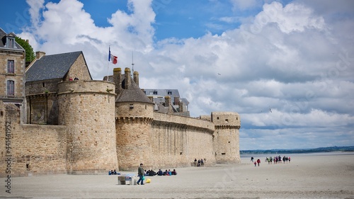 view on medieval village of mont saint michel with ramparts from the bridge crossing the bay