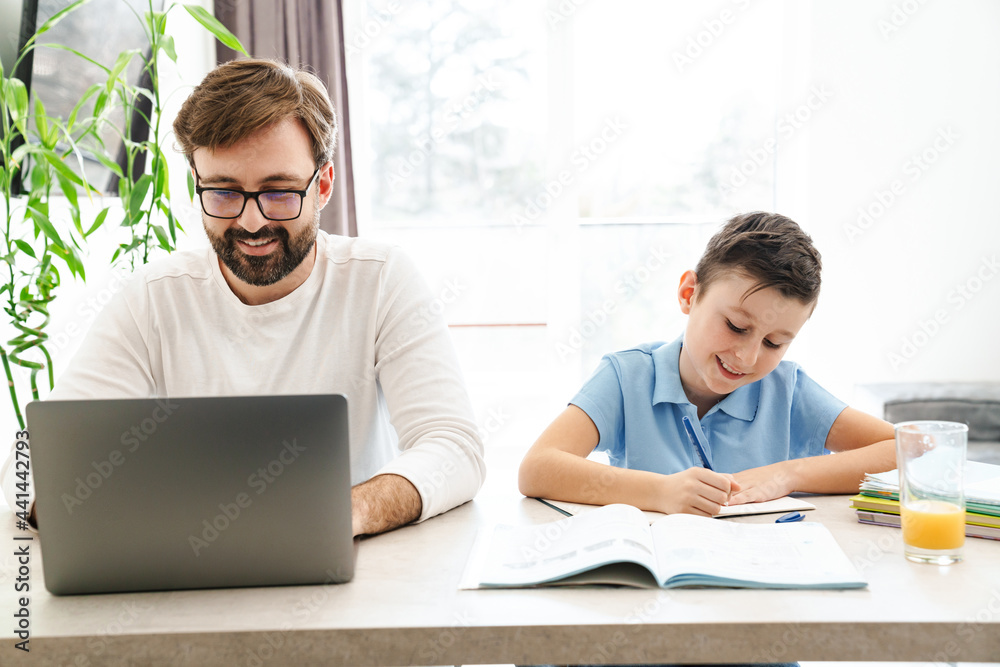 Father and son using laptop in the kitchen Father and son using laptop in the kitchen