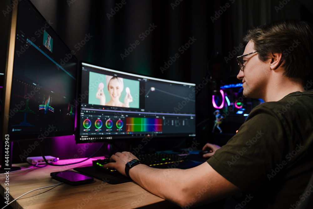 Back view of a young white man video editor Back view of a young white man video editor