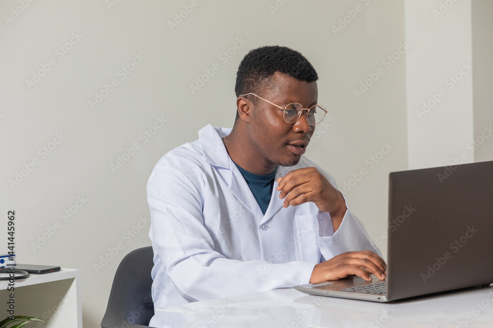 Young doctor gaining new knowledge using laptop Young doctor gaining new knowledge using laptop