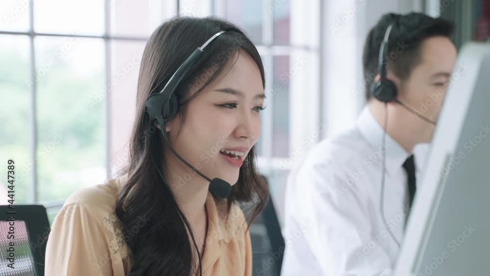 asian woman call center, Customer support agent or call center with headset works on desktop computer while supporting the customer on phone call. Operator service business representative concept
