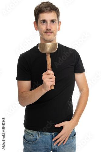 Young handsome tall slim white man with brown hair looks happy with tibetan singing bowl in black shirt isolated on white background
