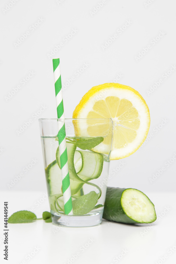 Fototapeta premium Lemon cucumber water with colorful paper straw. Healthy detox drink.