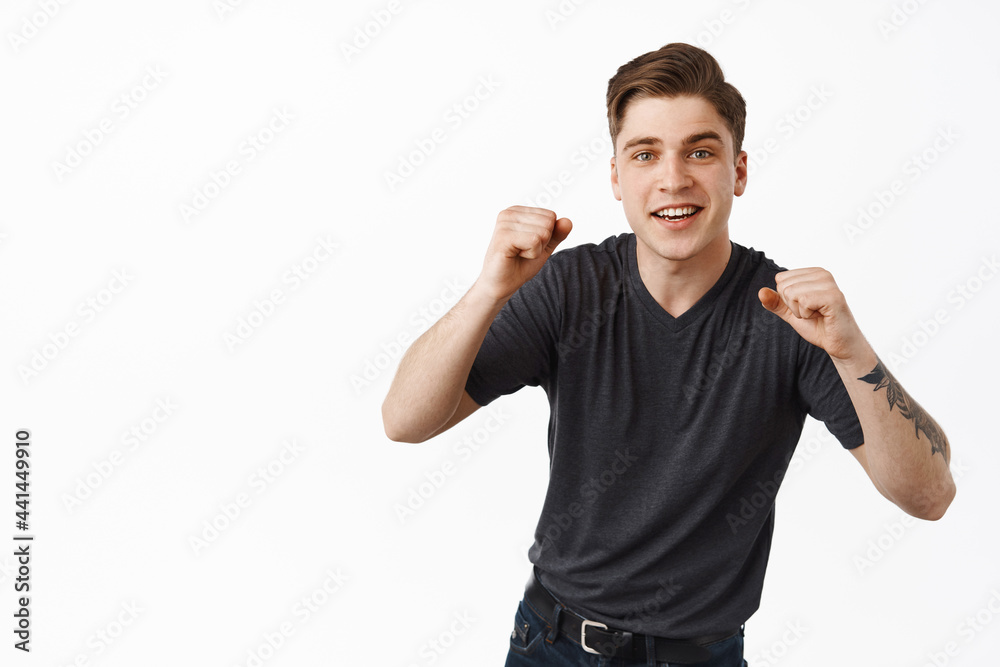 Image of hopeful young man clench fists look with excitement at tv screen, betting on something, rooting for team and wants to win, watching game, anticipating goal victory