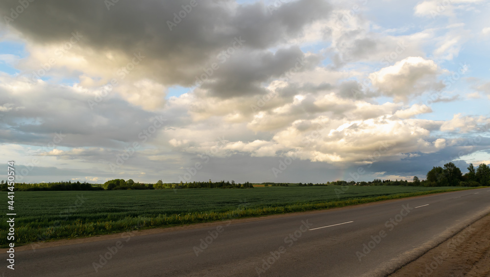 Clouds at sunset over an asphalted empty highway that runs between rural fields. Summer time. Horizontal photo.
Clouds at sunset over an asphalted empty highway that runs between rural fields. Summer time. Horizontal photo.