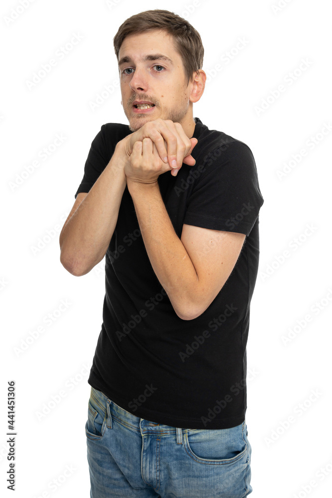 Young handsome tall slim white man with brown hair looks nervous in black shirt in blue jeans isolated on white background Young handsome tall slim white man with brown hair looks nervous in black shirt in blue jeans isolated on white background