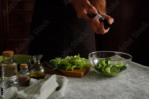 a man is preparing a vegetable salad. Adds spices