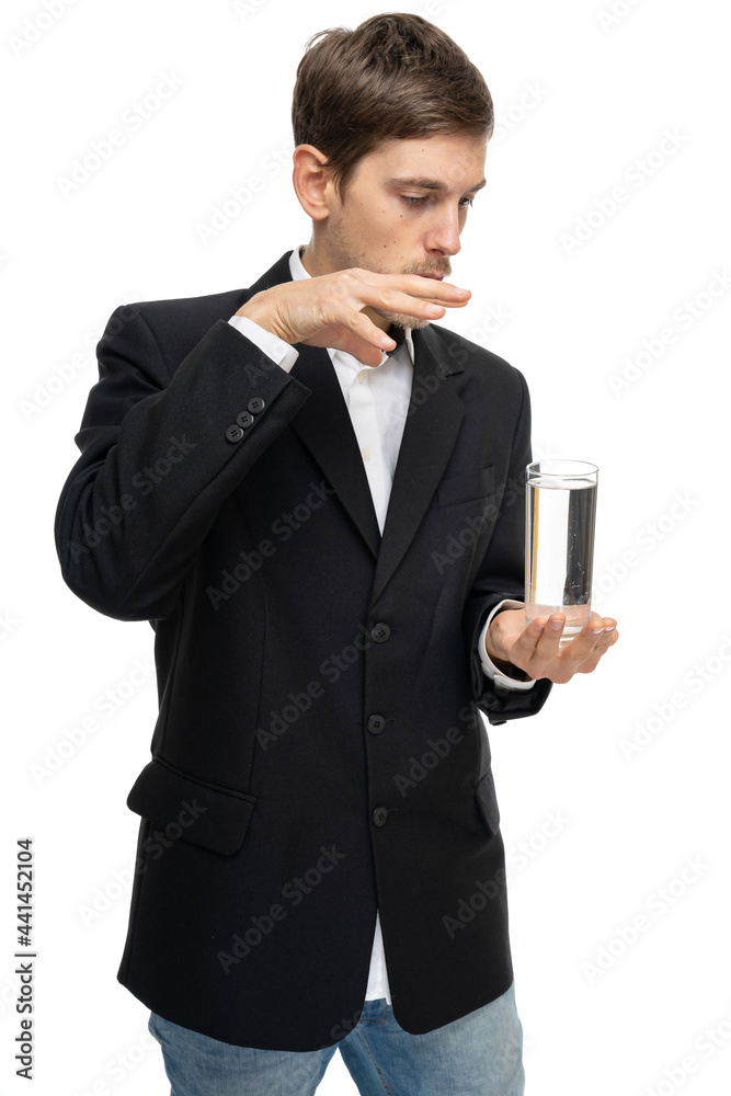 Young handsome tall slim white man with brown hair holding glass of water in black blazer isolated on white background Young handsome tall slim white man with brown hair holding glass of water in black blazer isolated on white background
