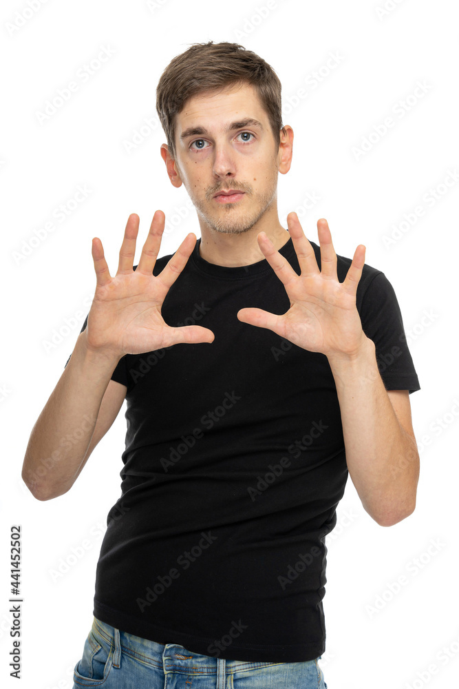 Young handsome tall slim white man with brown hair showing his palms in black shirt in blue jeans isolated on white background Young handsome tall slim white man with brown hair showing his palms in black shirt in blue jeans isolated on white background