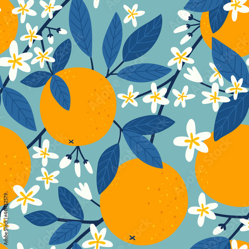 Tropical seamless pattern with oranges on blue background. Orange branch with flowers. Fruit repeated background. Design for fabric, wallpaper or wrap paper.
