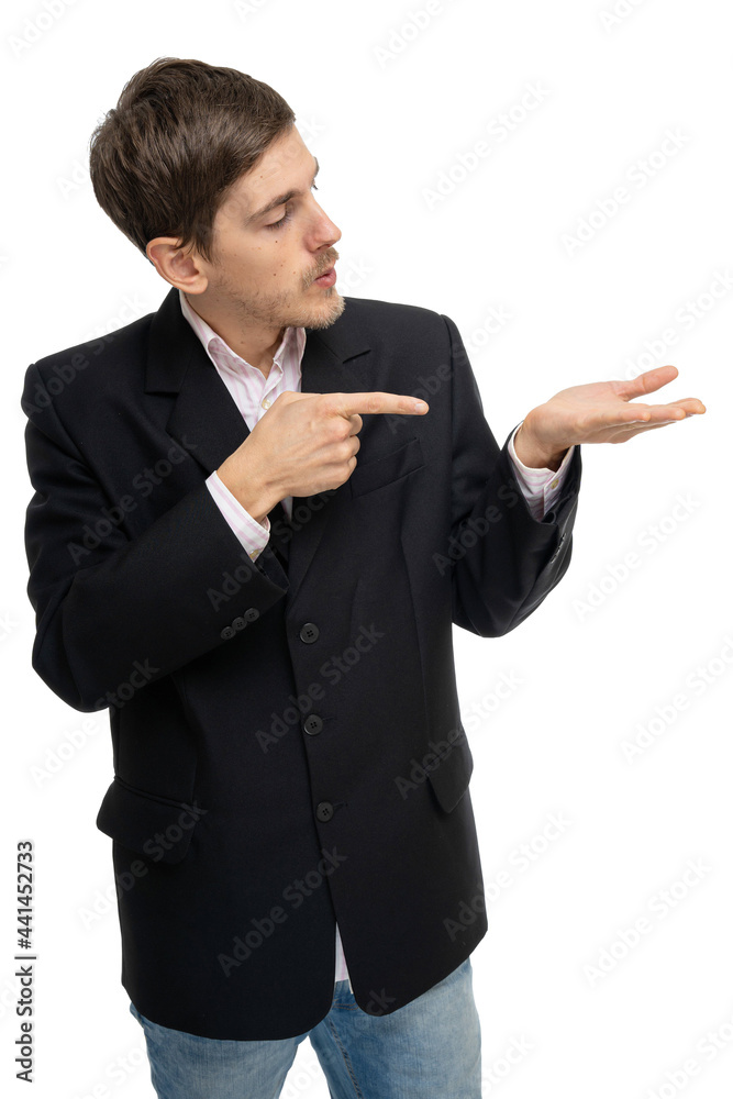 Young handsome tall slim white man with brown hair pointing at his palm in black blazer in blue jeans isolated on white background Young handsome tall slim white man with brown hair pointing at his palm in black blazer in blue jeans isolated on white background