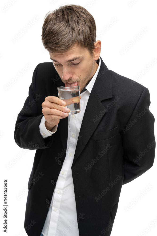 Young handsome tall slim white man with brown hair putting tongue in glass of water in black blazer isolated on white background Young handsome tall slim white man with brown hair putting tongue in glass of water in black blazer isolated on white background