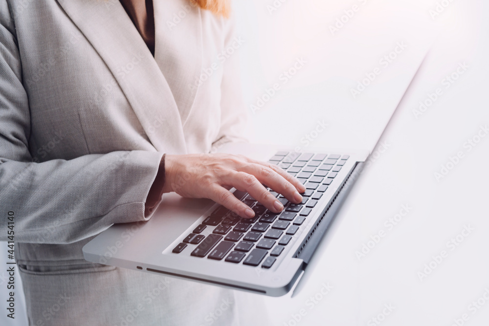 businesswoman hand working with laptop computer, tablet and smart phone in modern office with virtual icon diagram at modernoffice in morning light