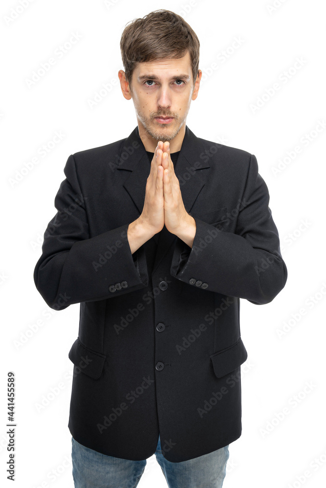 Young handsome tall slim white man with brown hair with clasped hands in black blazer in blue jeans isolated on white background Young handsome tall slim white man with brown hair with clasped hands in black blazer in blue jeans isolated on white background