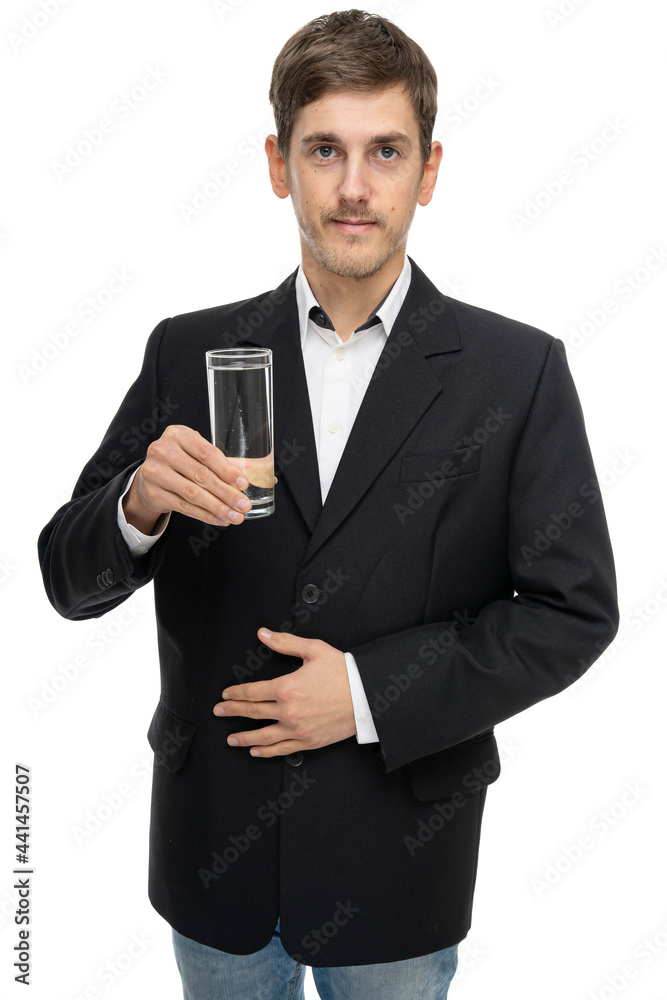 Young handsome tall slim white man with brown hair with glass of water in black blazer isolated on white background