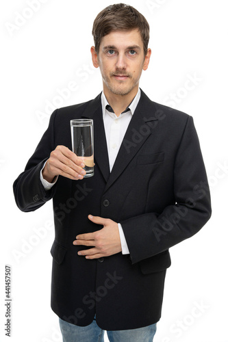 Young handsome tall slim white man with brown hair with glass of water in black blazer isolated on white background © PIXbank