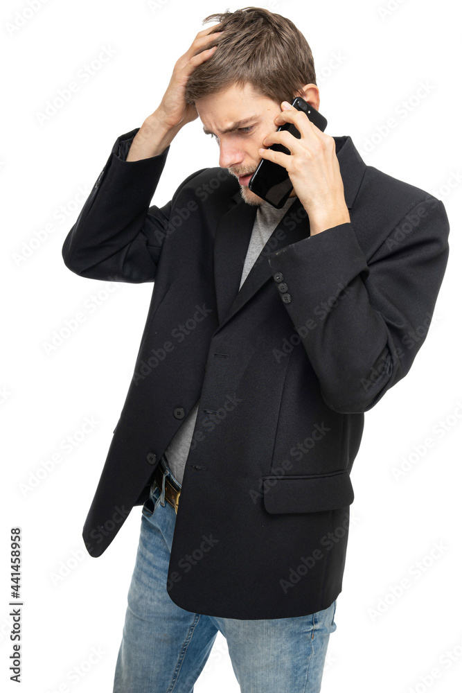 Young handsome tall slim white man with brown hair is on the mobile phone looks helpless in black blazer isolated on white background Young handsome tall slim white man with brown hair is on the mobile phone looks helpless in black blazer isolated on white background