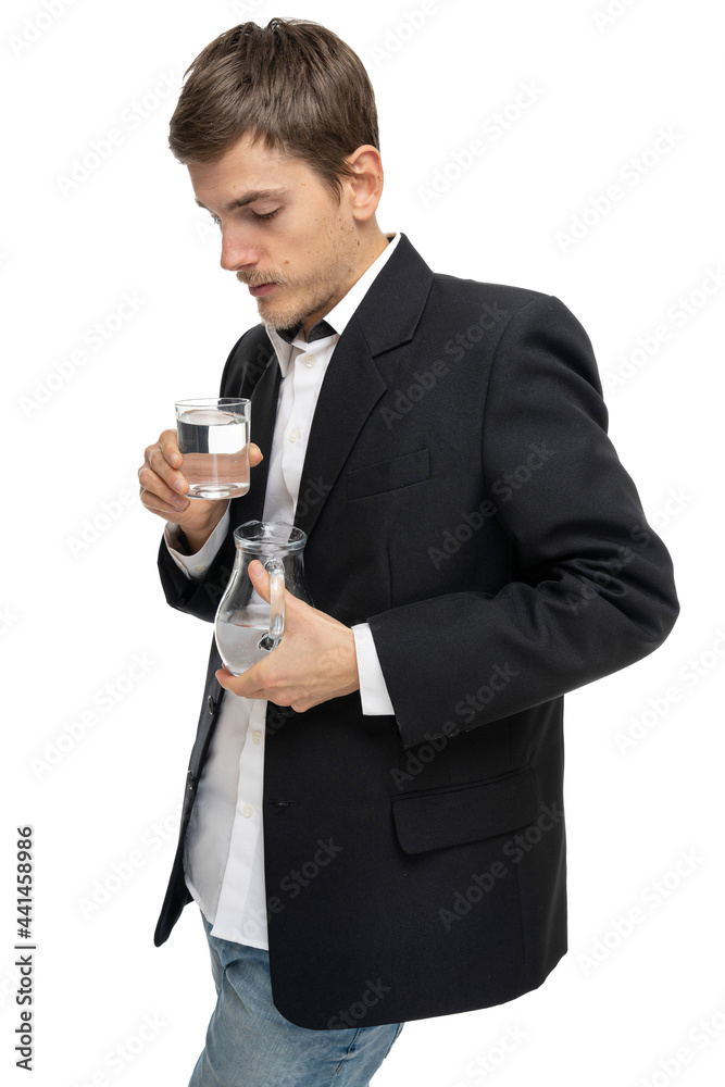 Young handsome tall slim white man with brown hair looking at glass of water and glass pitcher of water isolated on white background Young handsome tall slim white man with brown hair looking at glass of water and glass pitcher of water isolated on white background
