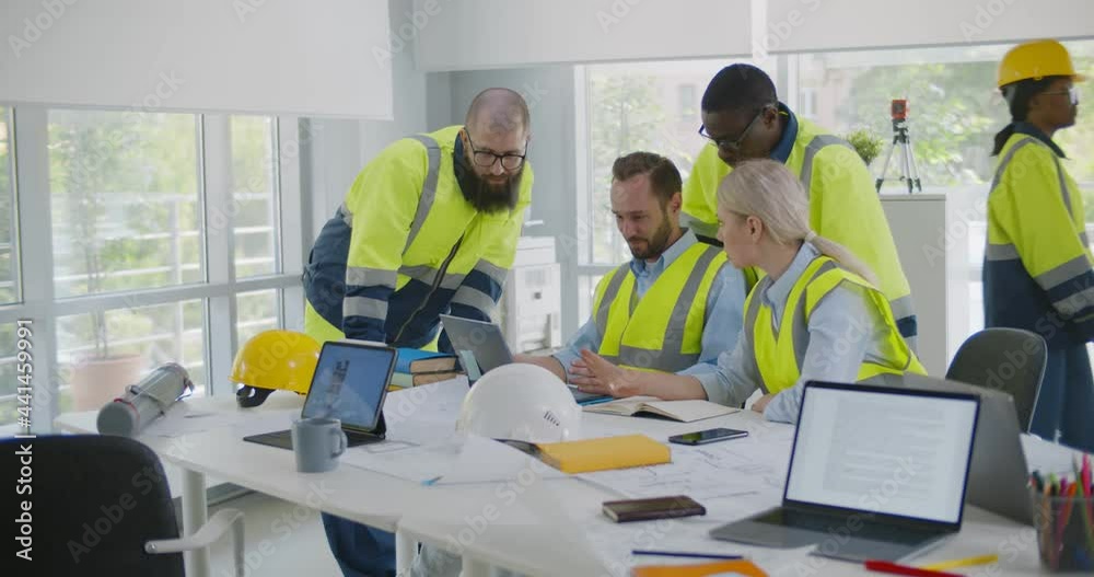 Professional diverse engineers discussing new project using laptop in office