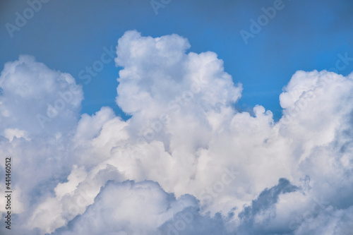 Lift your head up and you will see beauty of sky. Thick white clouds in bright blue sky. Minimalistic background for ad text or desktop screensaver.