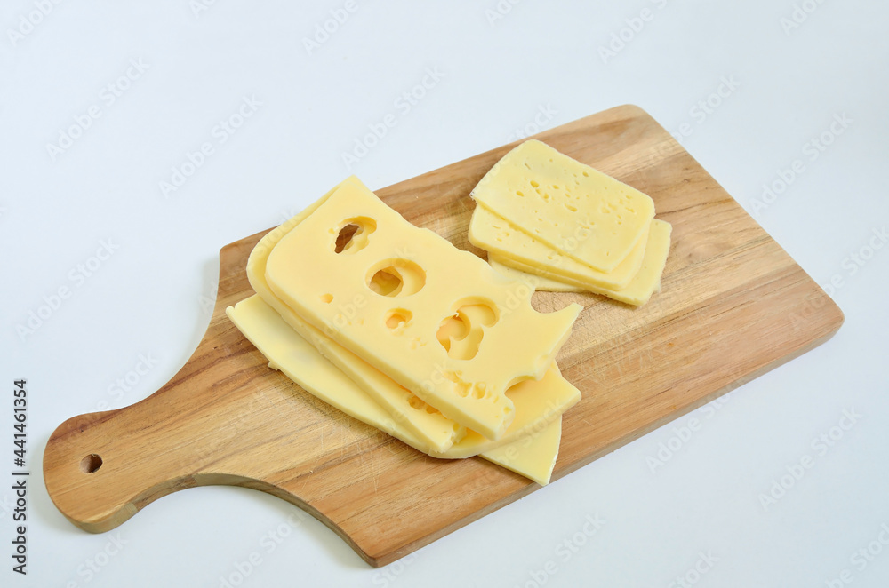 Slices of Emmental cheese and Tilsit cheese on cutting board