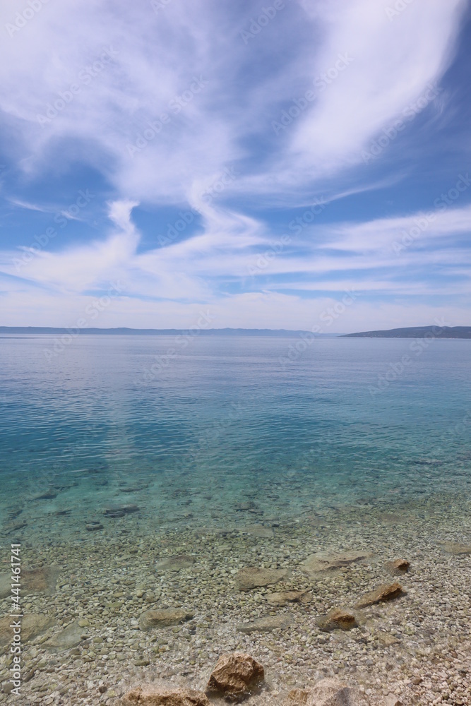 Picturesque clouds in the blue sky over the turquoise sea on a summer sunny day Picturesque clouds in the blue sky over the turquoise sea on a summer sunny day