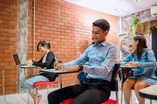 Students are taking exams to collect grades at the end of the semester And there is a young teacher supervising the exams in the classroom.