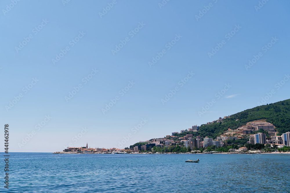 View from the sea to the buildings of Budva among the greenery in the mountains