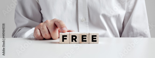 Foto Man pressing his finger on the wooden cubes with the word free