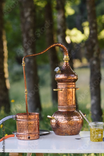 Antique copper still on an outdoor laboratory table photo