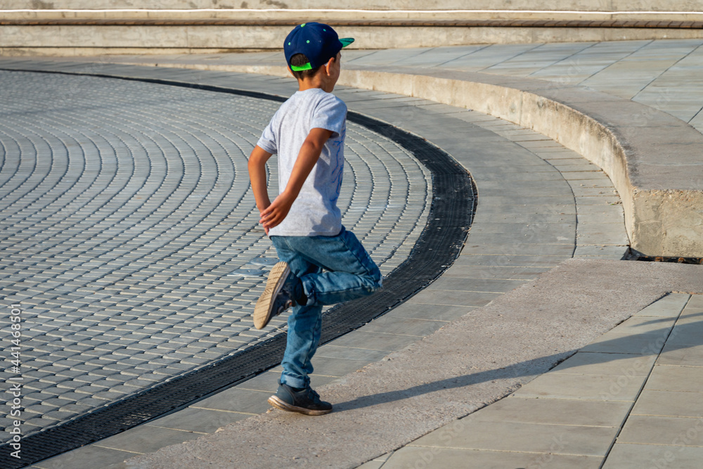 Fototapeta premium The boy is dancing in the street alone.
