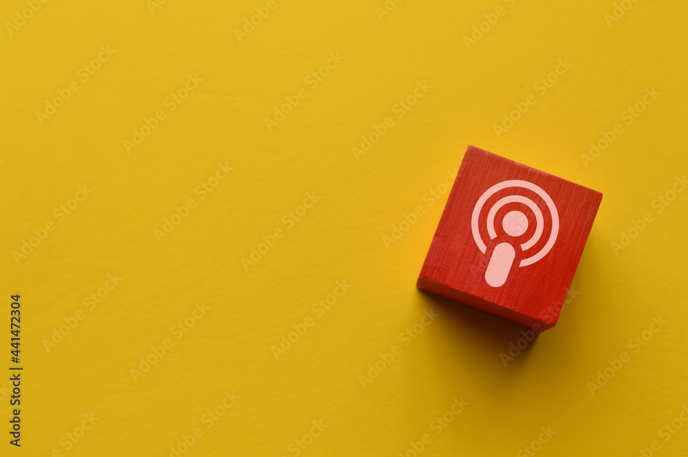 Wooden blocks with podcast icon isolated on yellow background Wooden blocks with podcast icon isolated on yellow background