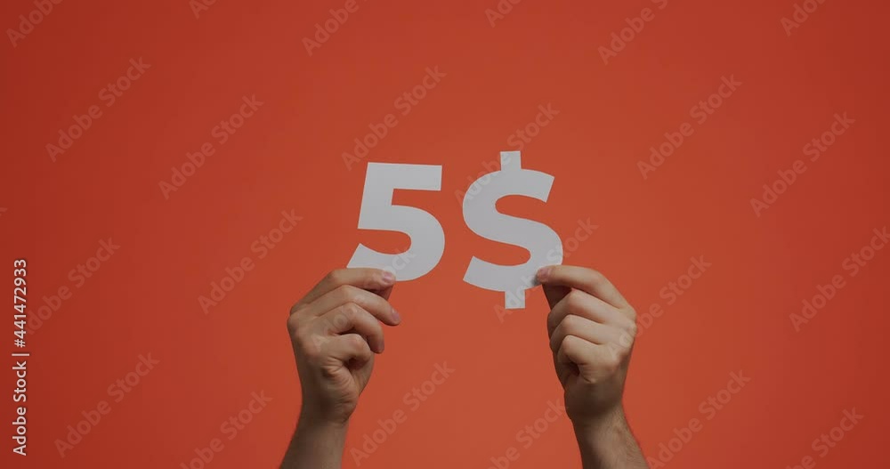 Five dollars, hands showing cost of purchase. Man show price made of carved paper. Sale, donating, auction concept Five dollars, hands showing cost of purchase. Man show price made of carved paper. Sale, donating, auction concept