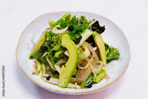 vegetable salad bowl with asparagus, fennel, avocado, raisins and mix lettuce in a bowl