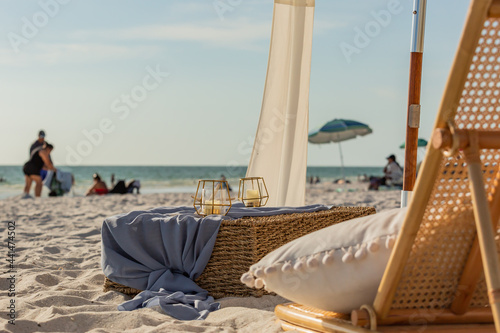 Obraz na płótnie Beach chair with pillow, candles, and a whicker crate box and umbrellas and the