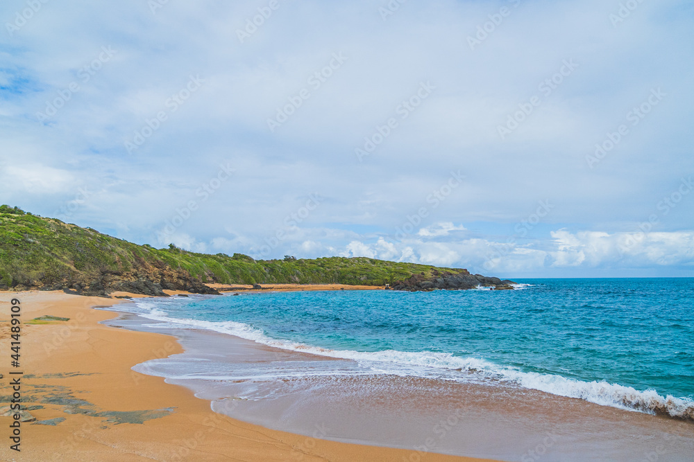 Panoramic view of tropical Red sand beach and blue water against sky