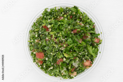 Overhead view of tabouli salad presented in a clear bowl for a Mediterranean meal on the go photo