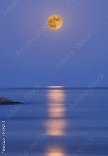 Full moon over the sea with reflections in the water