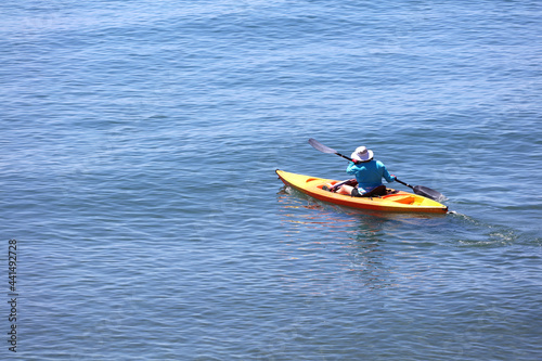 Senior person with kayak sails on the blue sea